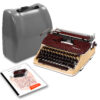 Vintage Olympia typewriter with burgundy top and beige body, shown with a gray carrying case and instruction booklet nearby.