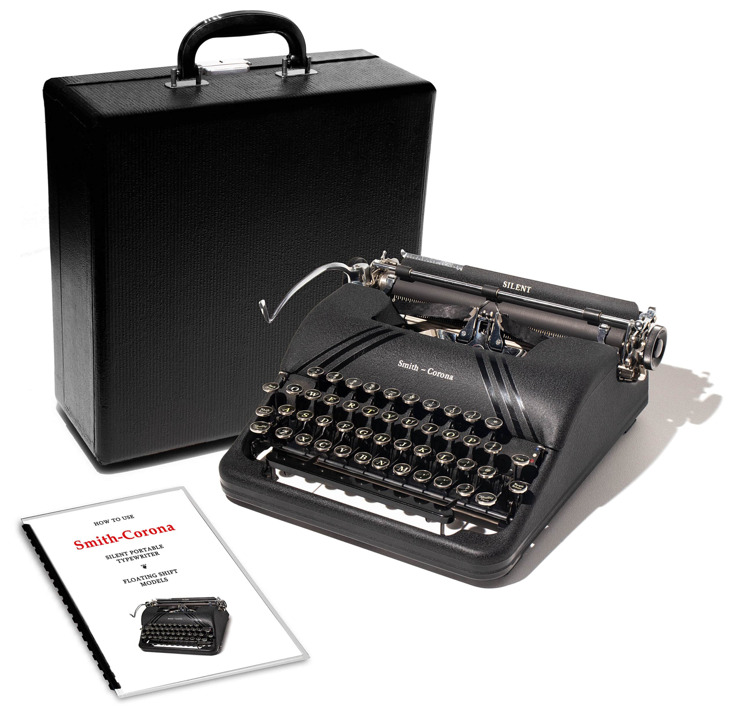 Portable Smith-Corona vintage typewriter with its black carrying case and instruction sheets nearby.