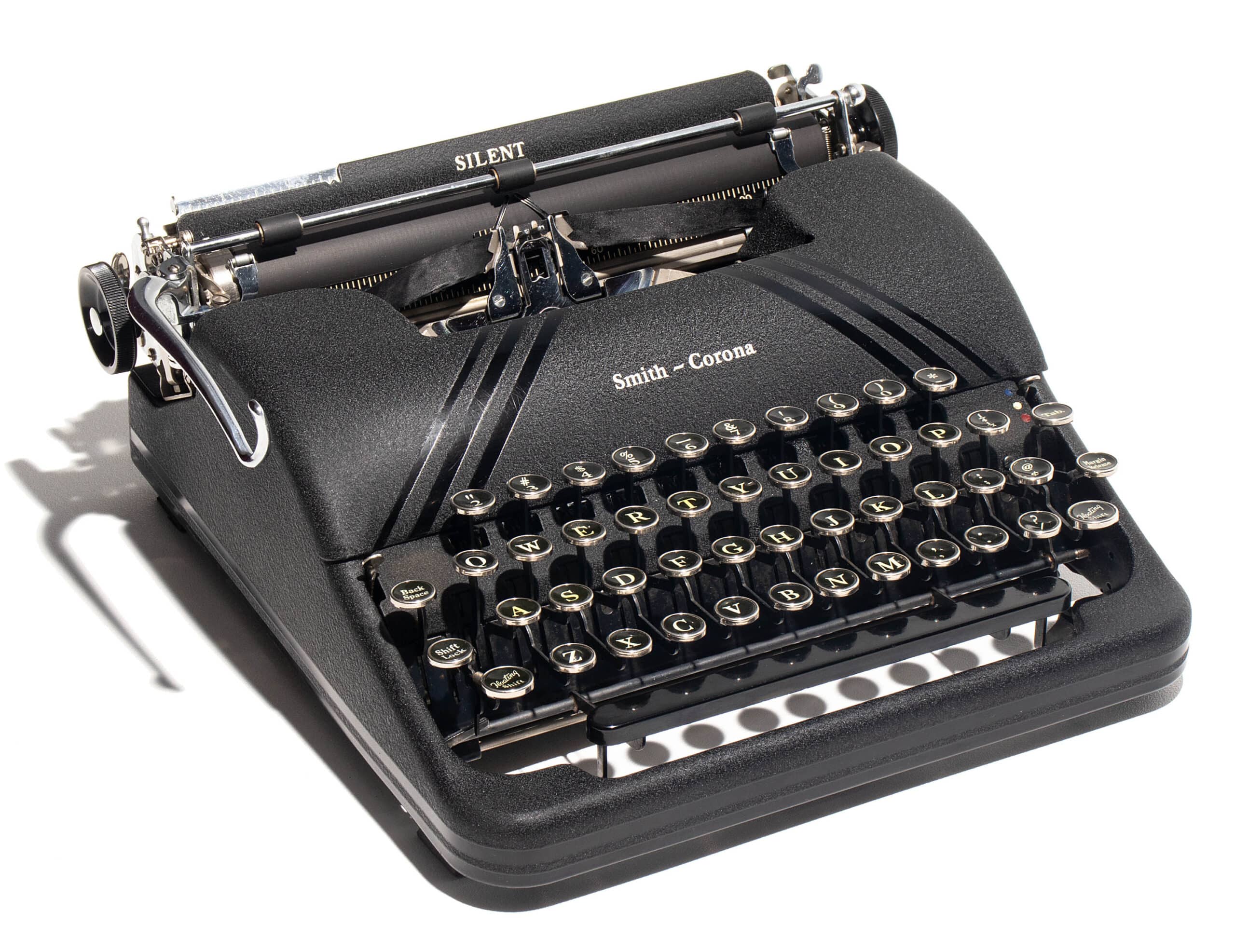 Vintage Smith-Corona manual typewriter with round keycaps on a black body, shown from the side.