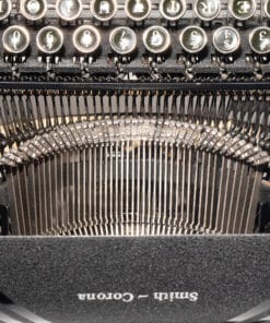 Close-up of a vintage typewriter interior: round metal keys above a row of type hammers and typebars.