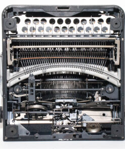 Interior view of a vintage typewriter showing type hammers, type bars, and ribbon mechanism exposed inside the frame