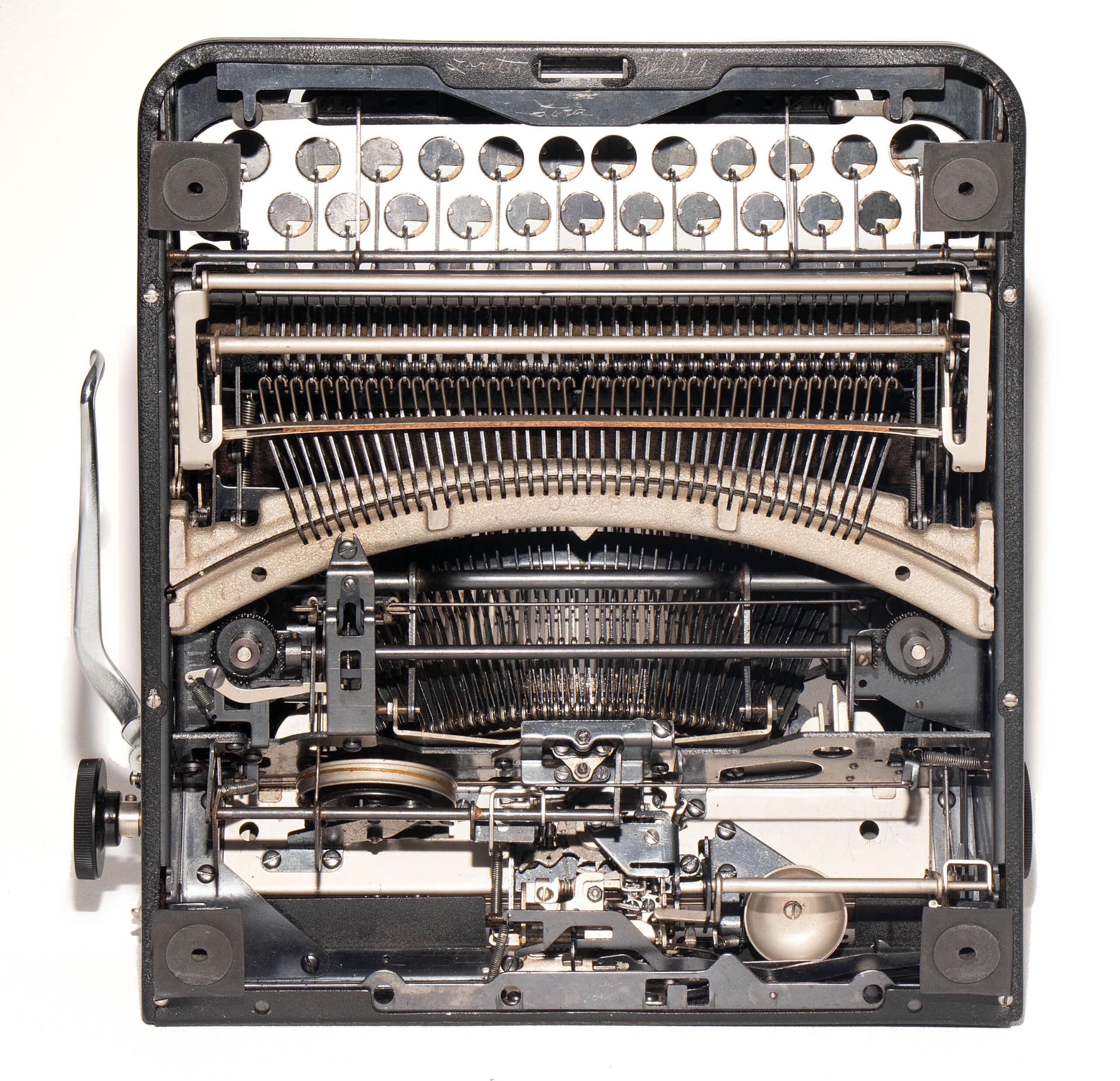 Interior view of a vintage typewriter showing type hammers, type bars, and ribbon mechanism exposed inside the frame