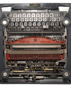 Interior view of a vintage typewriter's inner mechanism, with type hammers, ribbons, and metal levers visible.
