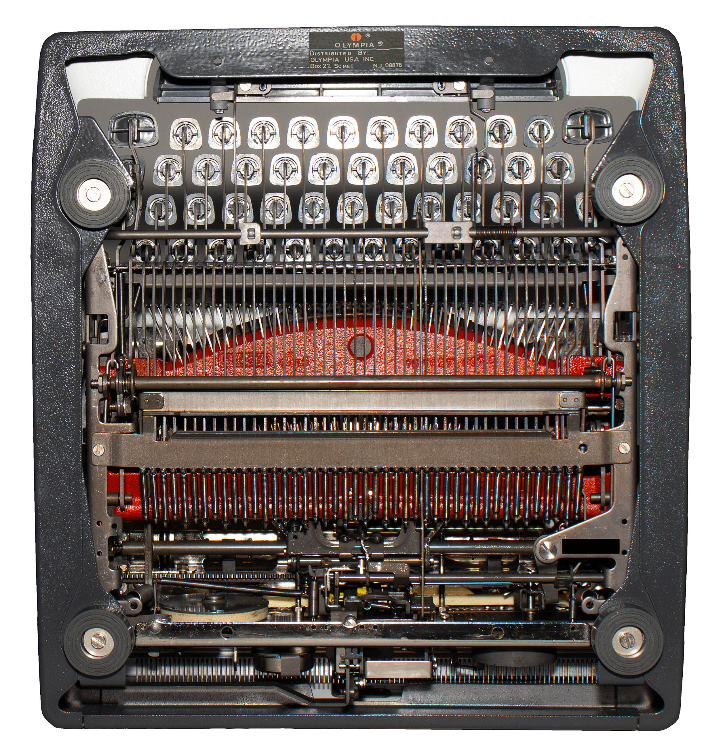 Interior view of a vintage typewriter's inner mechanism, with type hammers, ribbons, and metal levers visible.