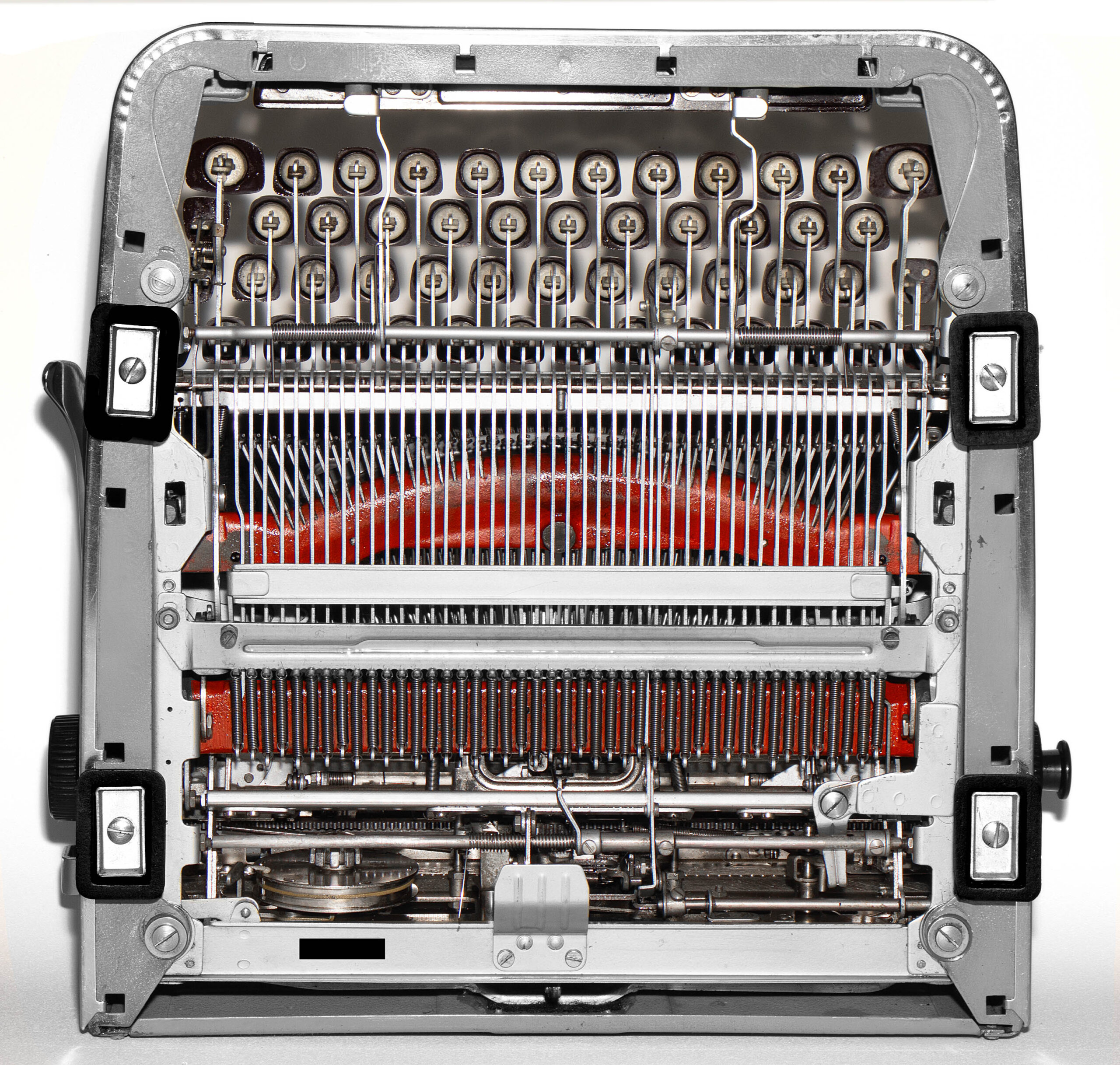 Close-up of a vintage typewriter's internal mechanism, showing type hammers, ribbon, and carriage gears.