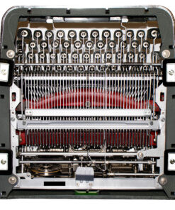 Close-up of a sewing machine's internal needle bar with many parallel needles and metal components.