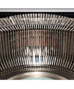 Close-up of a vintage typewriter's type hammers and metal type bars inside the machine, viewed head-on near the platen