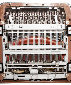 Exposed internal components of a vintage sewing machine, showing needle assemblies and metal gears/plunger mechanism.