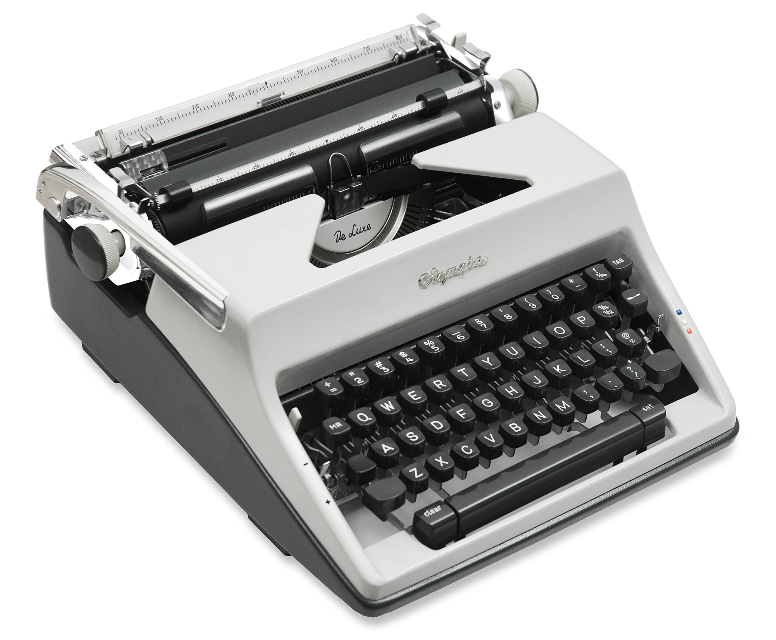 Close-up of a vintage De Luxe typewriter showing the typing mechanism, ribbon area, and row of black keys.