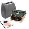 Vintage Olympia typewriter beside a grey carrying case with instruction manuals nearby, mid-century office setup.