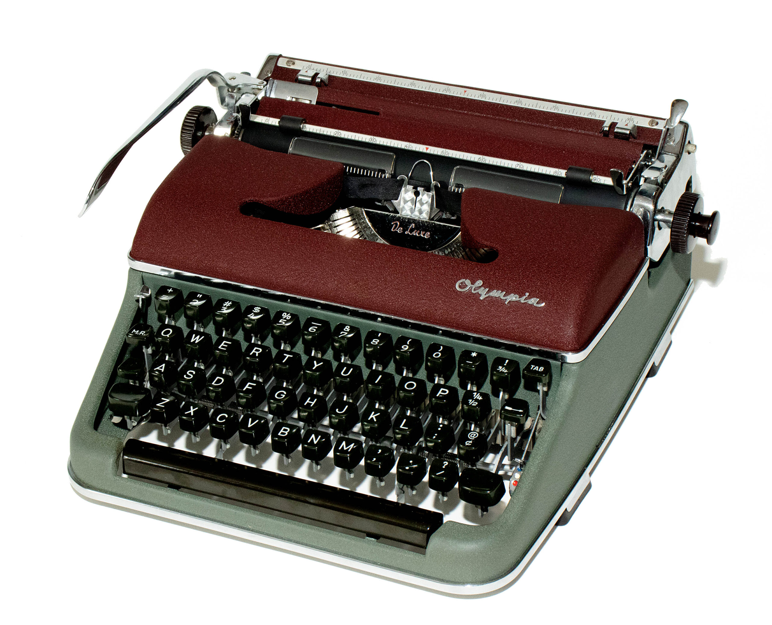 Vintage Olympia typewriter with burgundy housing and black keys, viewed from an angled top-left perspective.