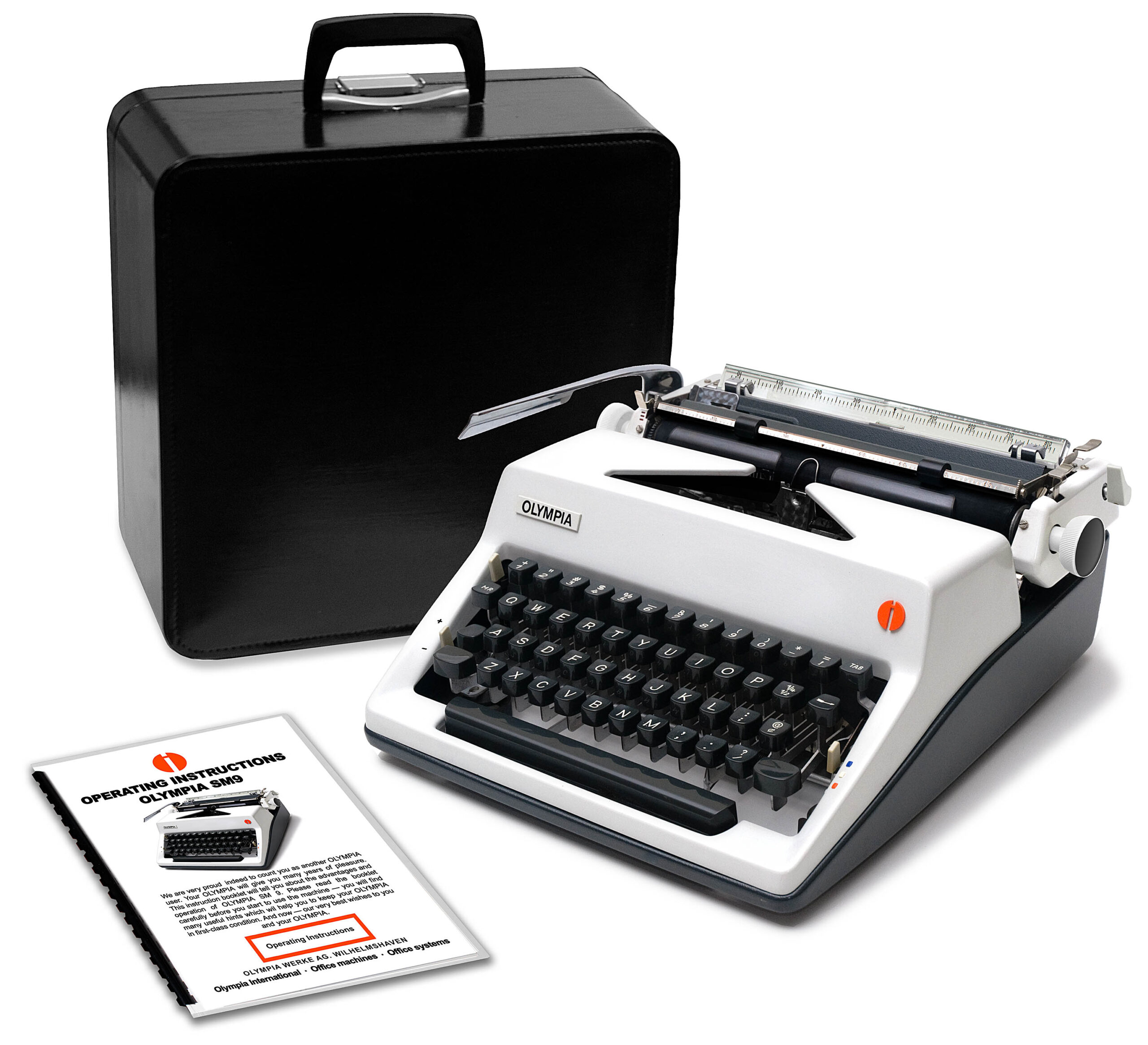 Vintage Olympia typewriter with a black carrying case and nearby operating manuals.
