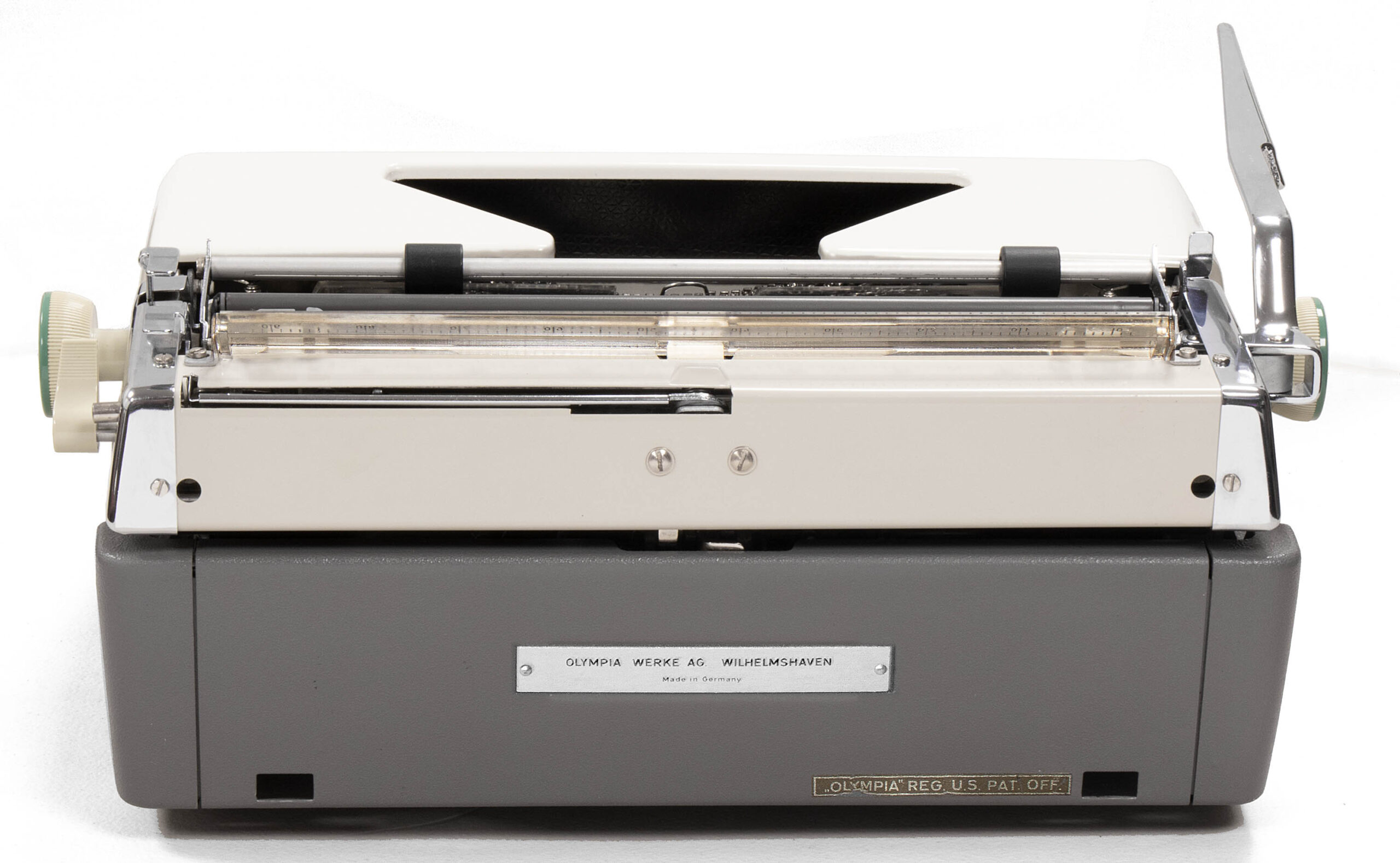 Front view of a vintage Olympia typewriter with a gray body and exposed metal carriage. A metal plate on the front bears the brand.