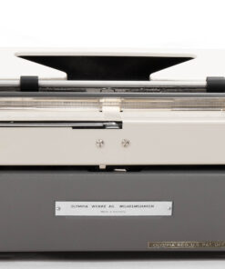 Front view of a vintage Olympia typewriter with a gray base and metal typing area; brand plate reads Olympia Werke AG Wilhelmshaven (Made in Germany).