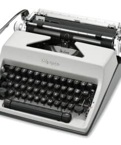 Close-up of a vintage gray manual typewriter showing the keyboard and metal carriage in a diagonal view, with 'De Luxe' lettering visible over the platen.