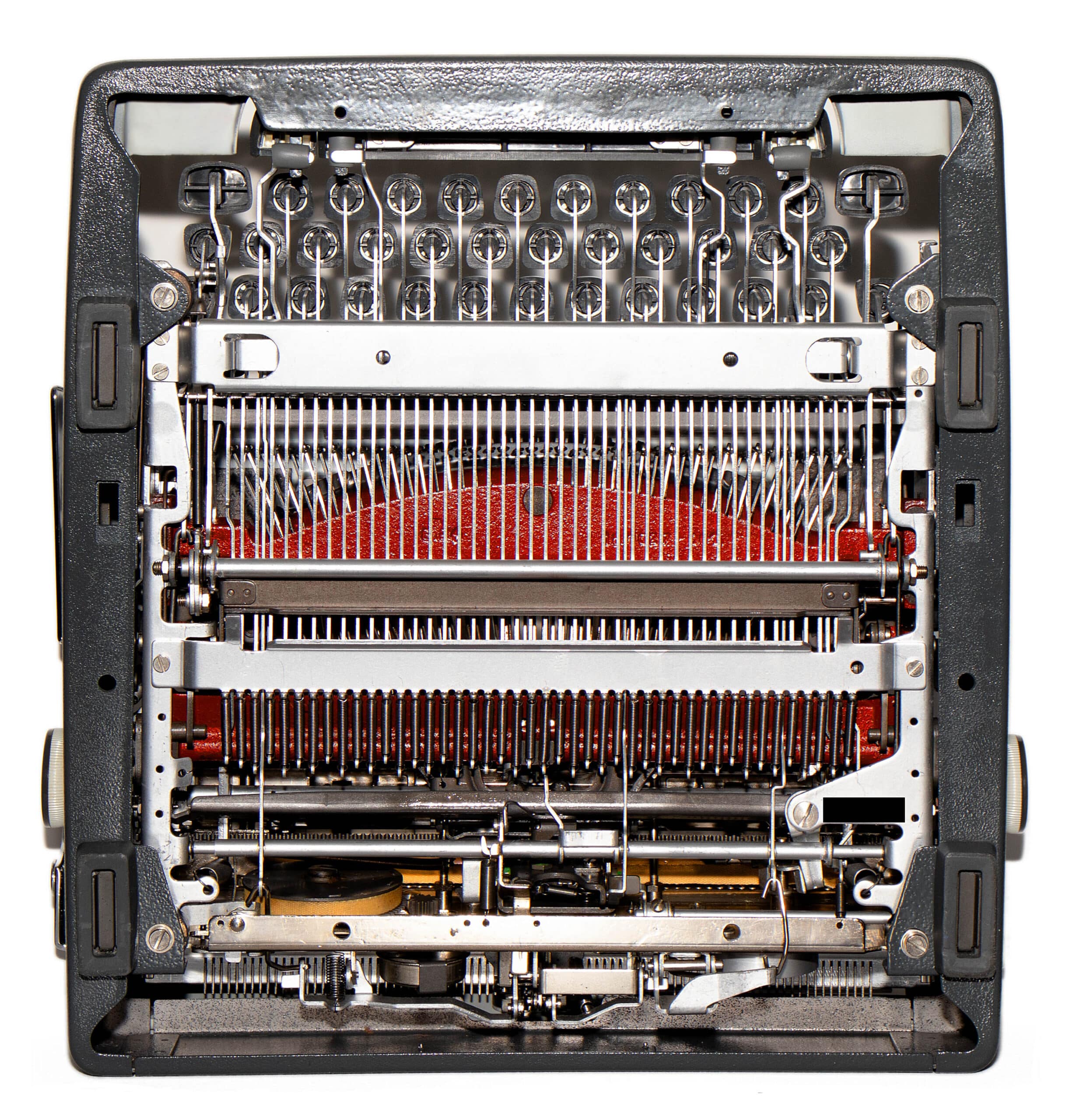 Close-up of a vintage typewriter’s inner mechanism with type slugs, hammers, and ribbon.