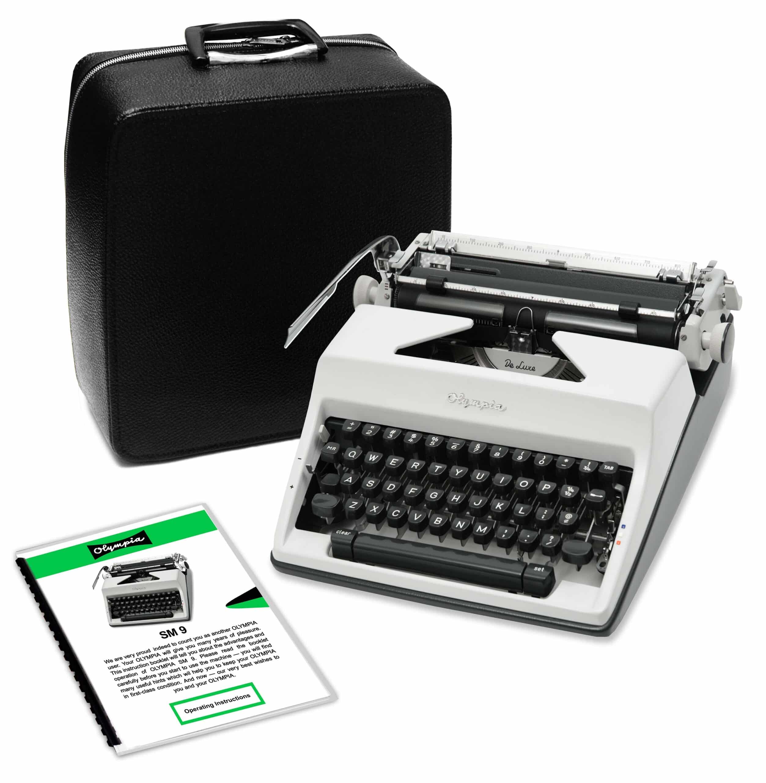 Portable black Olympia typewriter with open keyboard and visible typebars beside a black leather case and instruction sheets.