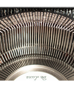 Macro view of a vintage typewriter’s inner type hammers arranged in a curved arc on the mechanism.