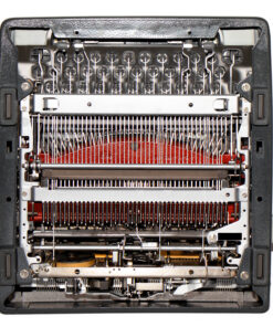 Close-up of an old mechanical typewriter's inner typing mechanism with type bars, ribbon, and carriage parts