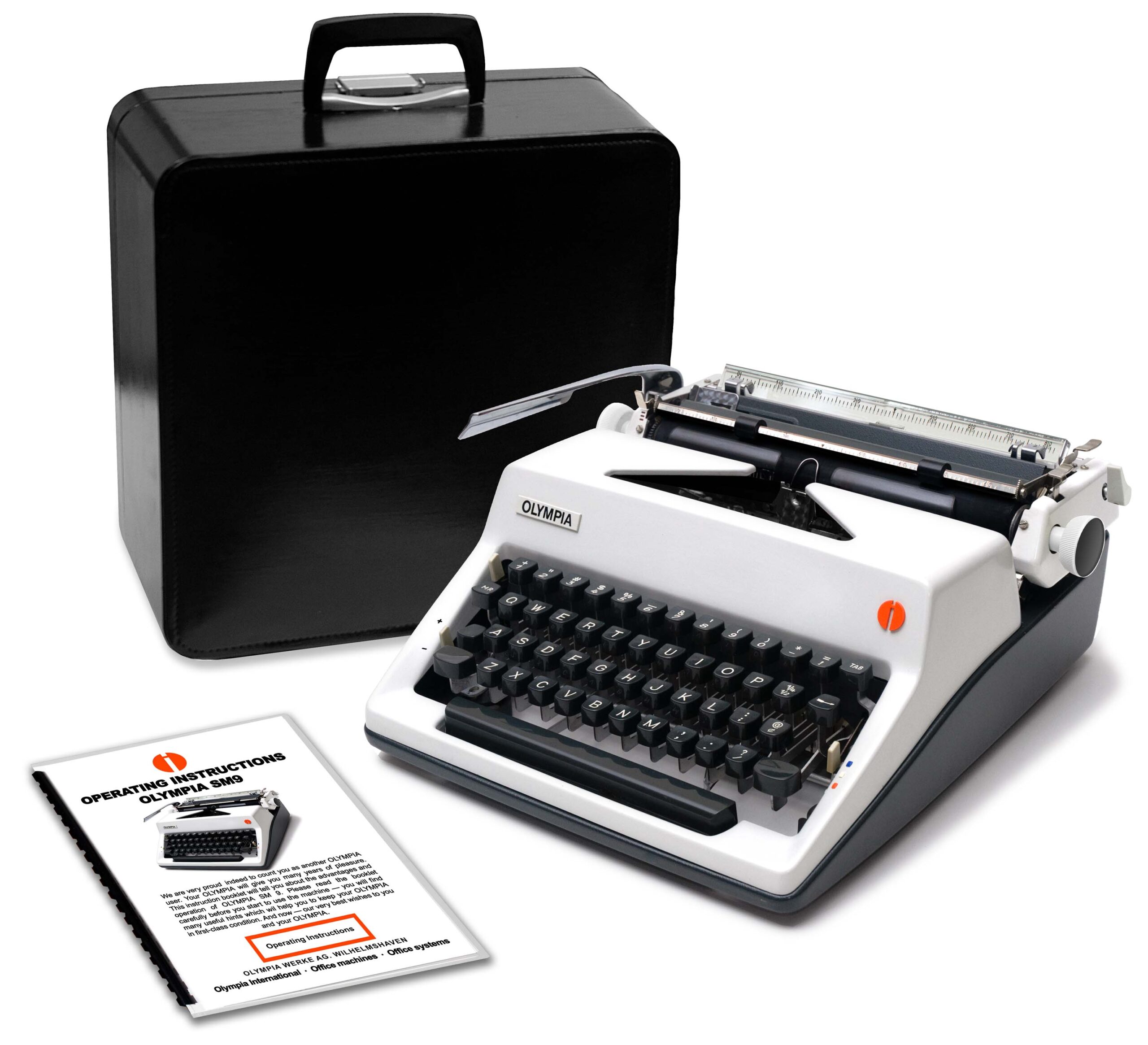 Old Olympia typewriter with a black carrying case and scattered instruction manuals on a white background (informative image).