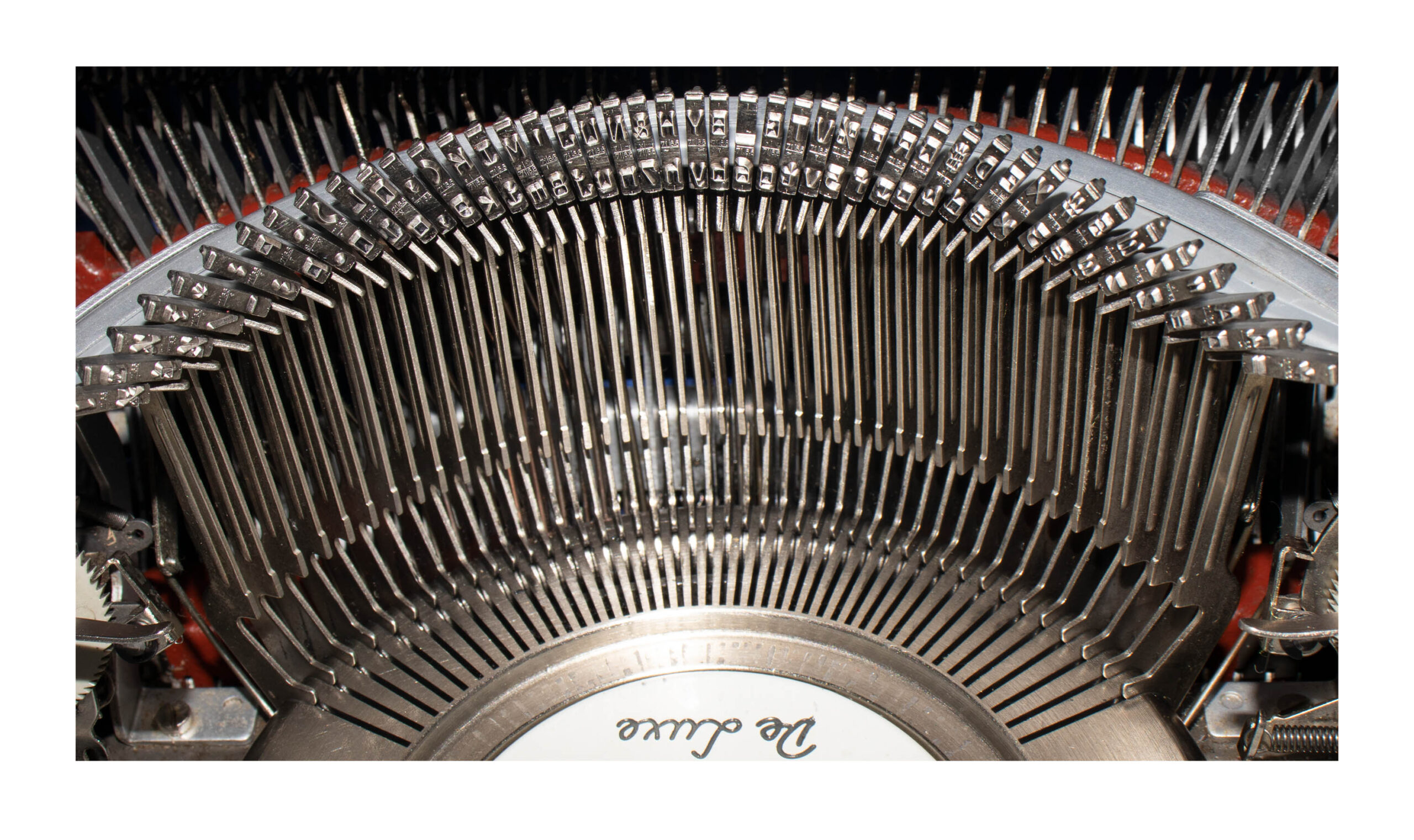 Close-up of a vintage typewriter's type bars and metal type slugs inside the machine.