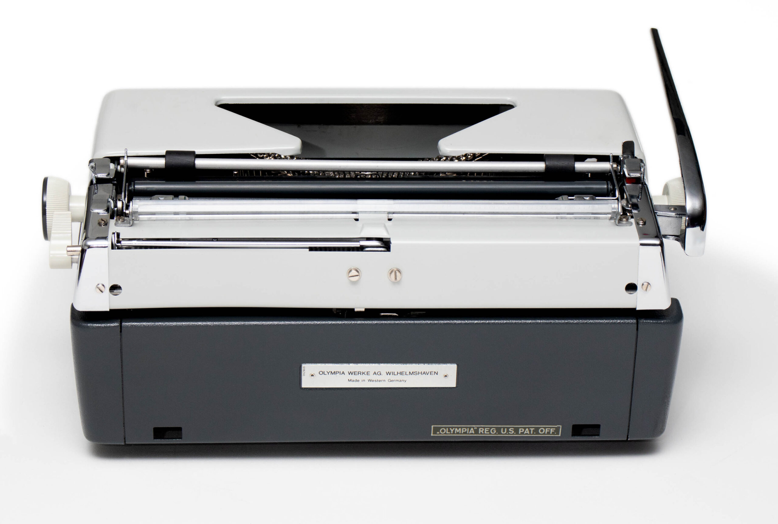 Top-front view of a vintage Olympia typewriter with visible type mechanism, white body and dark base.