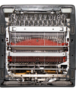 Close-up view of a vintage typewriter interior, showing the type hammers and the red ink ribbon.