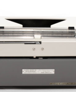 Front view of a vintage manual typewriter with a gray body and metal carriage, keys not visible.