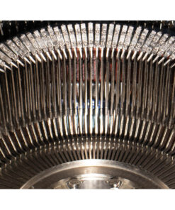 Close-up of a vintage typewriter's metal type bars and type slugs arranged in a curved arc.