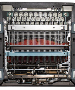 Internal view of a vintage typewriter with exposed typebars and hammers, showing the key wiring and ribbon area beneath.
