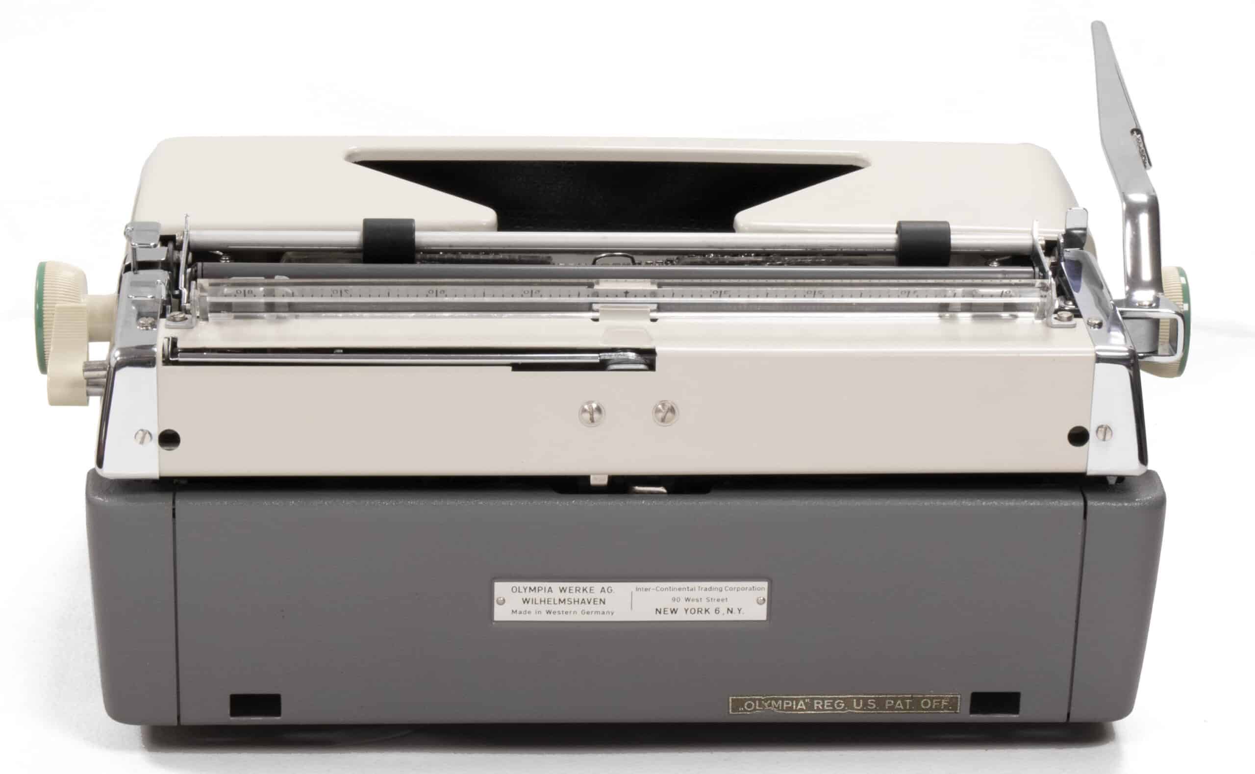 Front view of a vintage Olympia typewriter with a cream top and gray base, showing metal carriage and levers