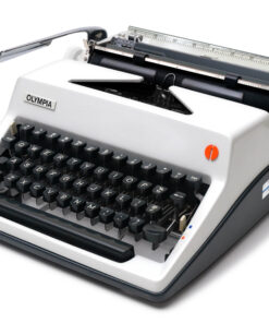 Vintage Olympia manual typewriter with black keys and metal carriage against a white background, shown from a front-right angle.