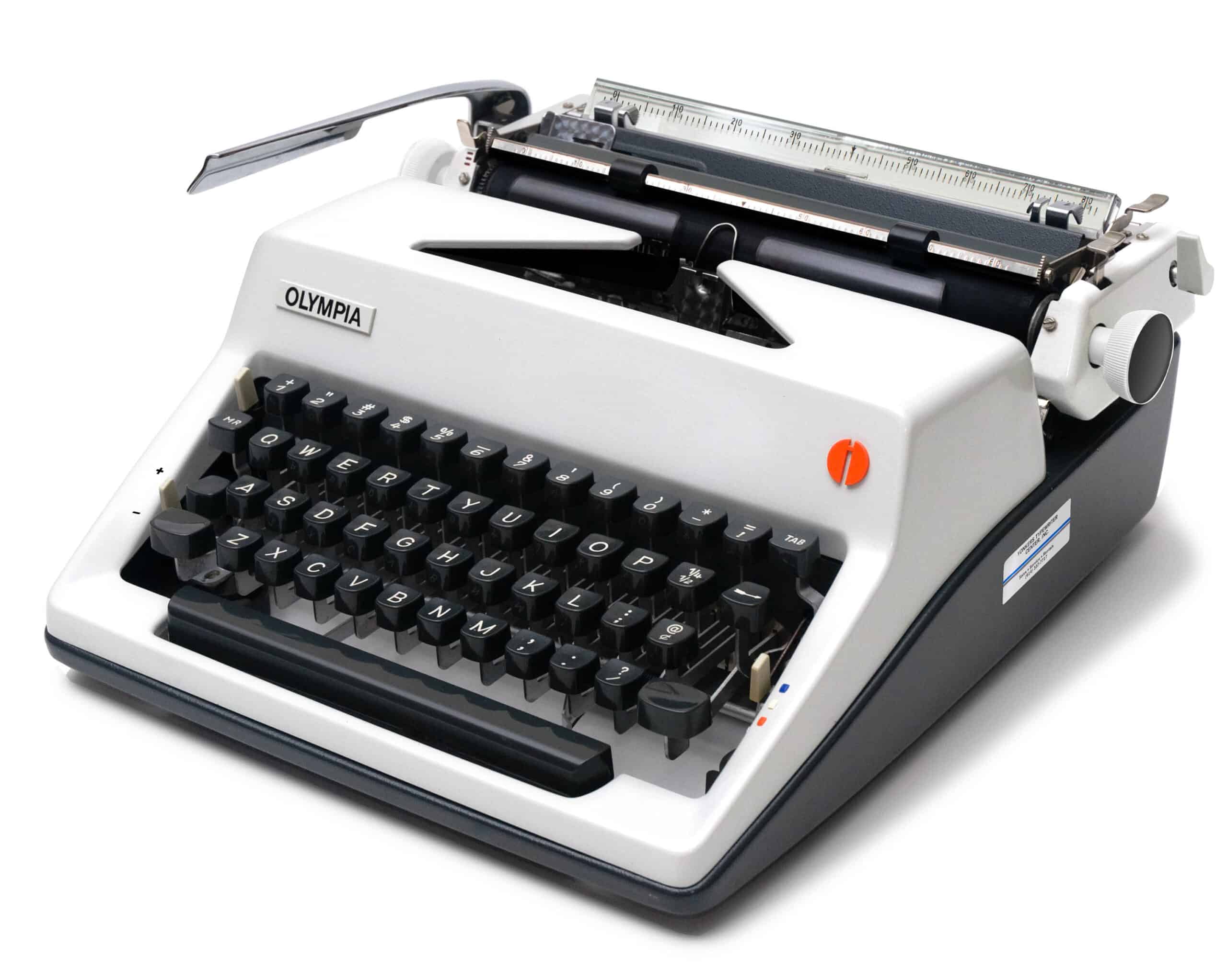 Vintage Olympia manual typewriter with black keys and metal carriage against a white background, shown from a front-right angle.