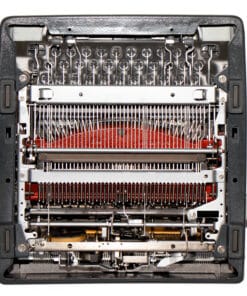 Close-up of a vintage typewriter's internal typebars, ribbons, and hammers visible inside the frame.