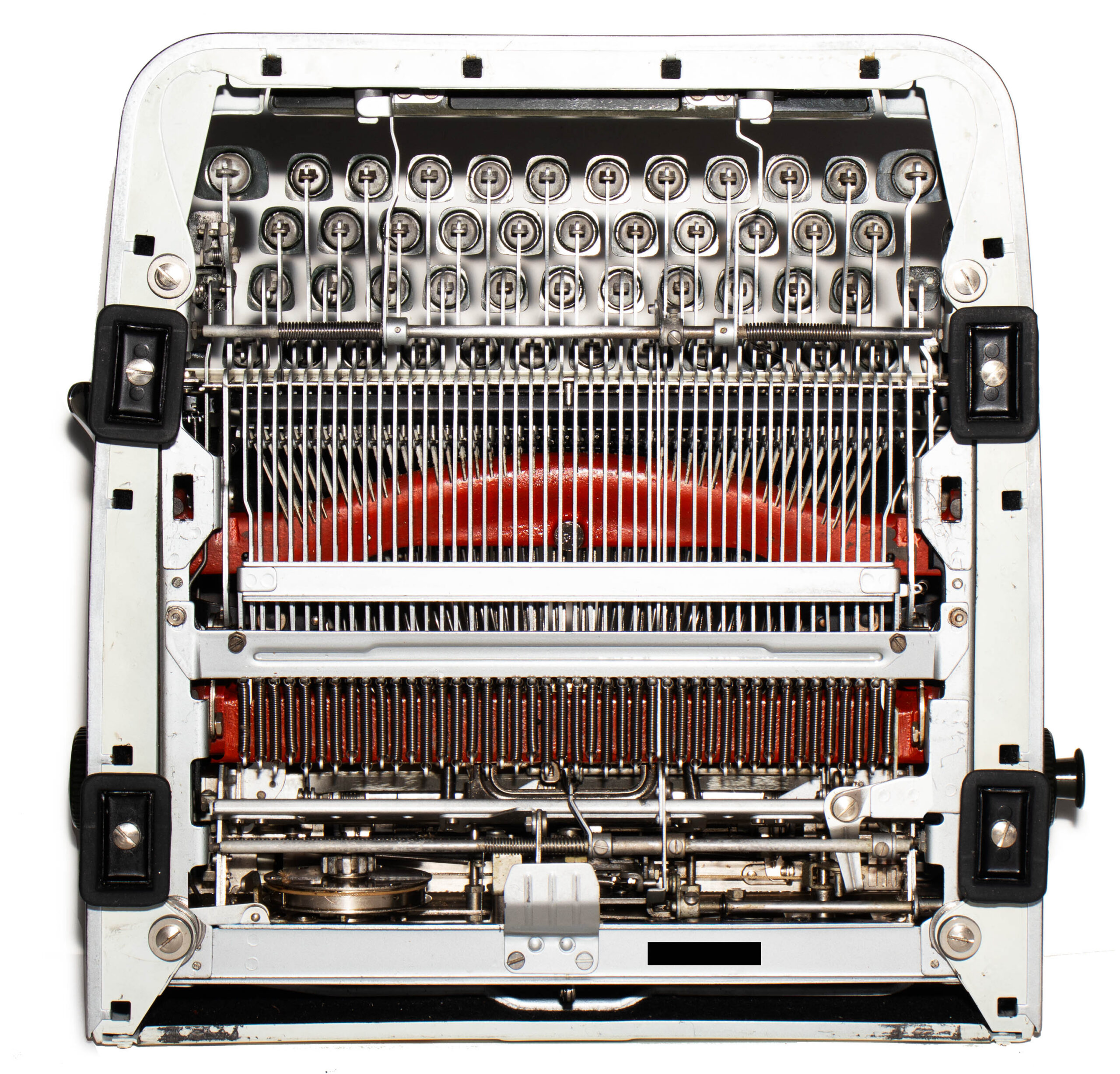 Close-up of a vintage typewriter's inner typebar mechanism with rows of keys and metal levers, red frame visible in the background.